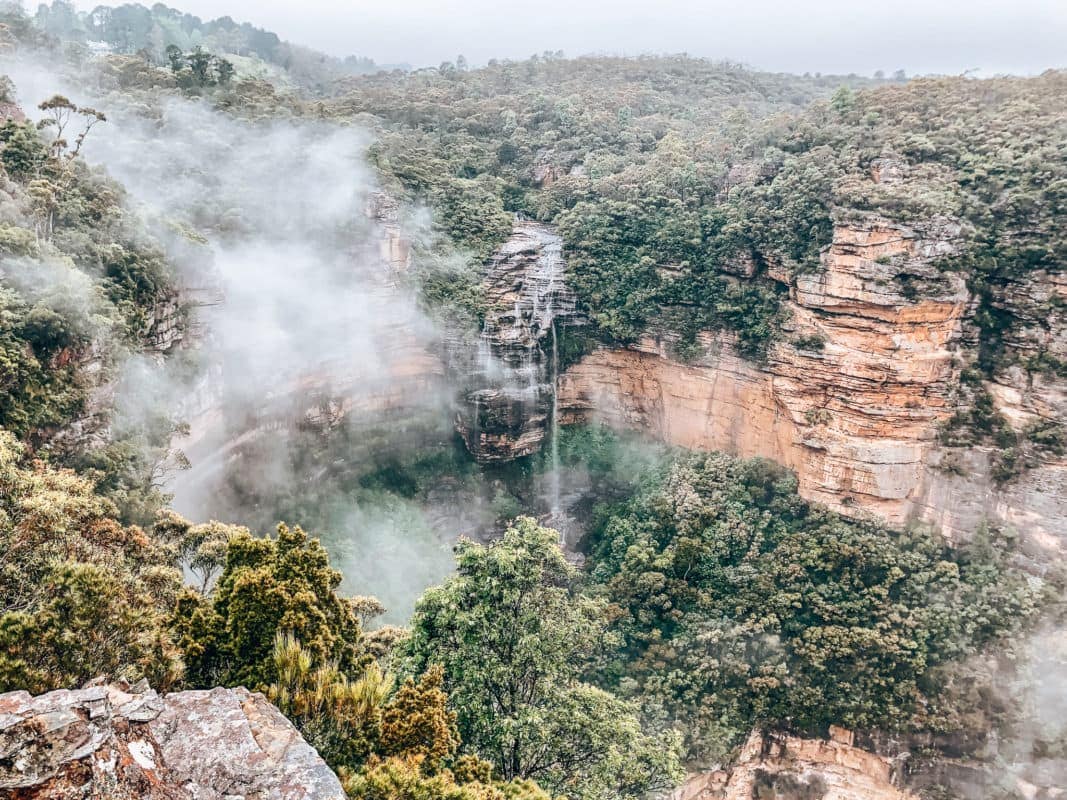 Hiken in de Blue Mountains
Als je in Sydney bent dan mag je een trip naar de Blue Mountains echt niet overslaan! Wat een mooie tocht
is dit en wij hebben onze ogen uitgekeken. Onderschat de route niet, want hij is best heftig. Wij hadden wel
de pech dat het die dag regende en dat zorgde ervoor dat niet alle uitkijkpunten even helder waren. Desondanks was het schitterend. Via steile trappen daal je helemaal af naar beneden waar je zicht hebt op
de waterval vanuit onder gezien. Tijdens deze trip stop je het grootste deel van de tijd bij de Blue Mountains, maar er is ook een stop ingelast om de drie gezusters te kunnen spotten.
